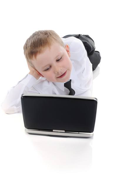 Little boy lying on the floor with a laptop. - Zdjęcie, obraz