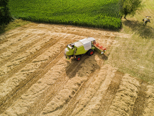 Vista aérea de la cosechadora combinada en tierras de cultivo en Suiza  - Foto, Imagen