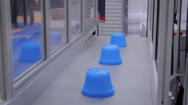 Automatikus robot gyártósor mozgó műanyag kék cserépben a futószalagon - Felvétel, videó