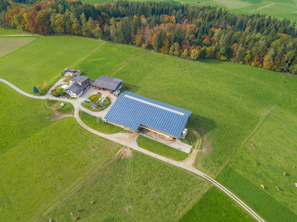 Luftaufnahme von Photovoltaik auf Dächern von landwirtschaftlichen Gebäuden in Europa. Gebäudeintegriertes Pv für Solarenergieerzeugung. - Foto, Bild