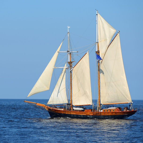Old historical tall ship (yacht) with white sails in blue sea - Photo, Image