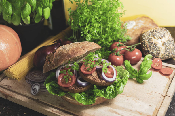 hamburger végétarien savoureux au pain de seigle avec tomates et oignons
  - Photo, image