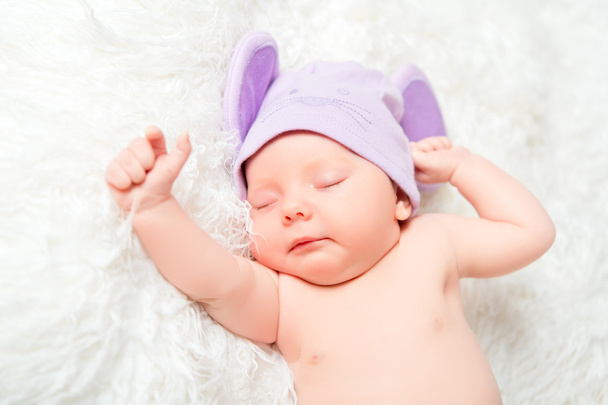 Niedliches Neugeborenes schläft in einem Hut mit Ohren - Foto, Bild