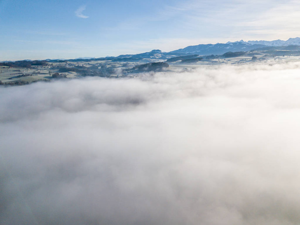 スイスの農村風景の空中ビューは霧で覆われて.  - 写真・画像