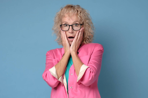 Worried surprised woman in glasses looking with surprise on prices. - 写真・画像