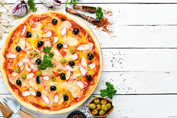 Traditional Italian pizza with crab sticks and olives. Top view. free space for your text. Rustic style. - 写真・画像