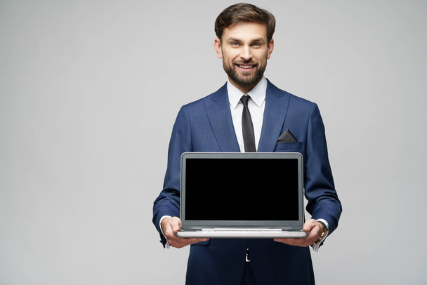 Young handsome businessman Holding a laptop Computer with Blank Screen - Zdjęcie, obraz
