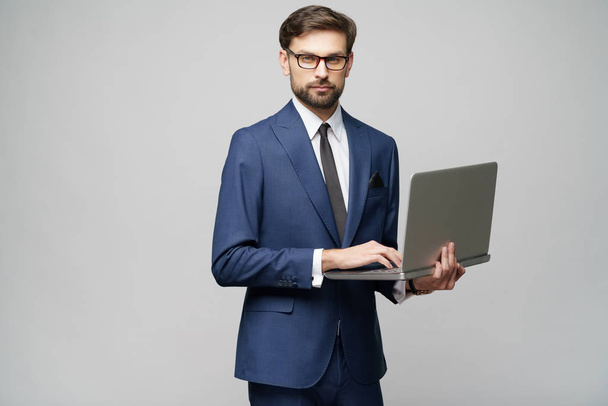 Young handsome businessman Holding a laptop Computer with Blank Screen - 写真・画像