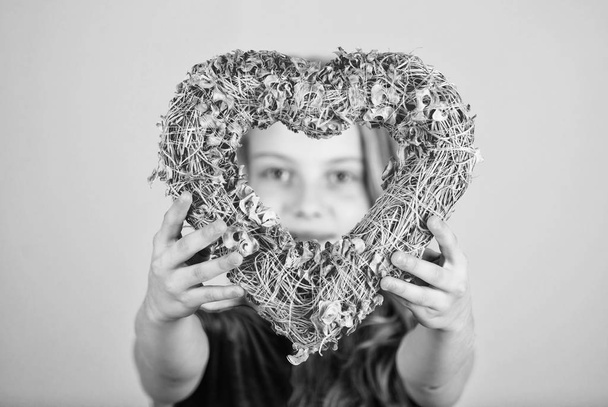 Love concept. Girl cute child show heart shaped decor. Symbol of love. Kid adorable girl with long hair happy face show heart to you. Look in heart part. Celebrate valentines day. Love holiday decor - Photo, Image