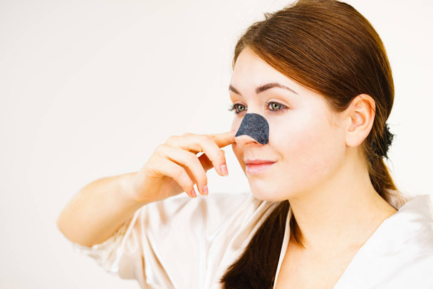 Woman applying pore strips on nose - Photo, image
