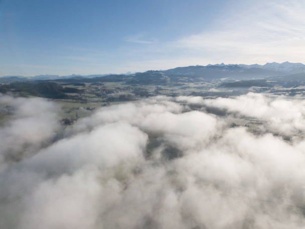 Aerial view of rural landscape in Switzerland covered with fog.  - Fotoğraf, Görsel