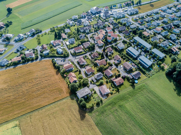 Luchtfoto van landelijk dorp in Zwitserland met gebouwen - Foto, afbeelding