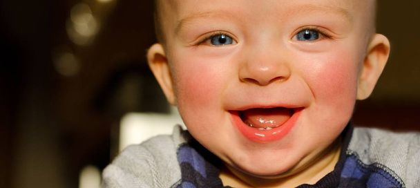 Lähikuva muotokuva onnellinen lapsi kaunis hymy, joka osoittaa hänen kaksi ensimmäistä hammasta
.  - Valokuva, kuva