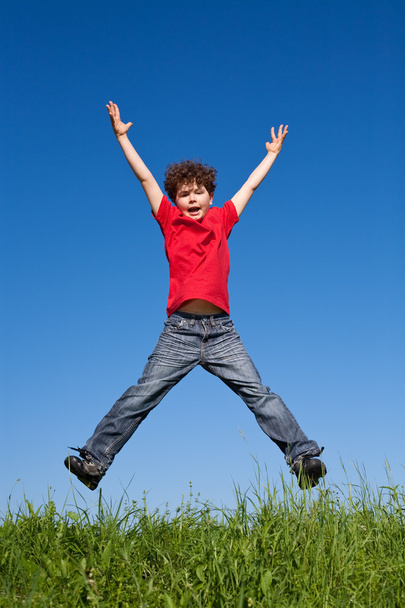 Boy jumping against blue sky - Foto, Imagen