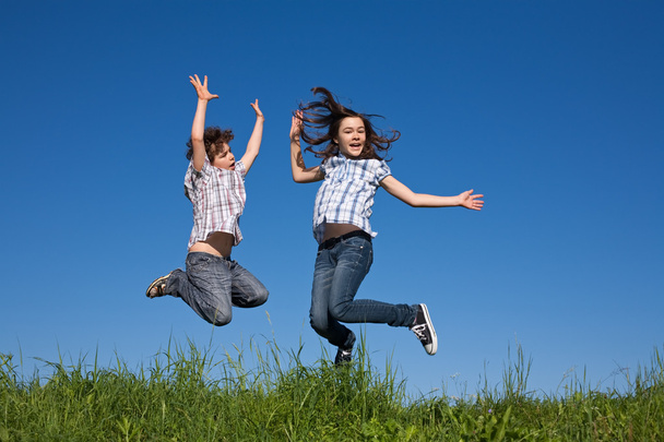 Girl and boy jumping outdoor - Photo, image