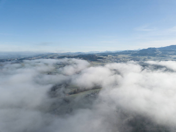 Aerial view of rural landscape in Switzerland covered with fog.  - Fotó, kép