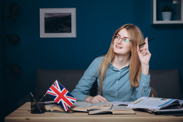 Jeune fille roux anglais étudiant en lunettes assis
 - Photo, image