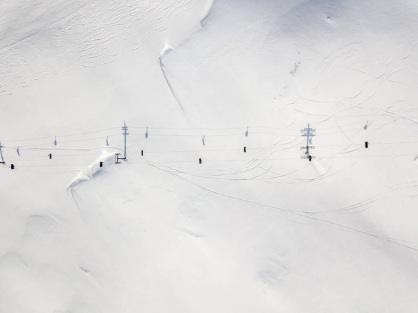 Aerial view of ski chairlift on snow covered mountain in Switzerland - Photo, Image