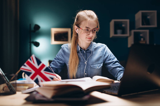 Ragazza concentrata in occhiali e auricolari Studiare inglese
 - Foto, immagini