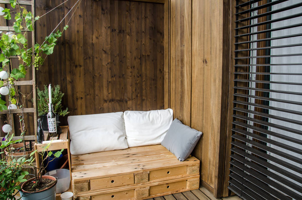 Cozy wooden pallet couch on balcony - Valokuva, kuva