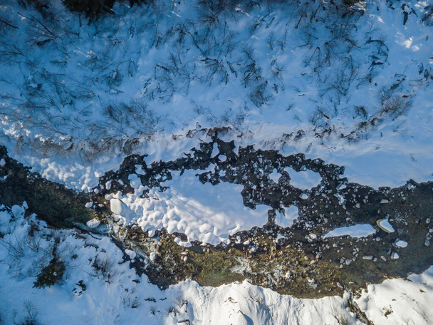 Вид з повітря на снігові камені в річці, що тече взимку
 - Фото, зображення