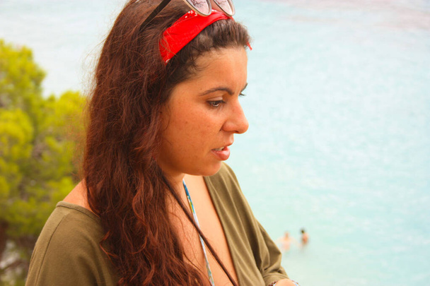 primo piano di paffuto bruna caucasico ragazza in estate su una scogliera tra gli alberi con vestito verde rosso bandana testa e occhiali da sole
 - Foto, immagini