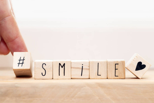 Holzwürfel mit einem Hashtag und dem Wort smile, Social-Media-Konzept Hintergrund - Foto, Bild