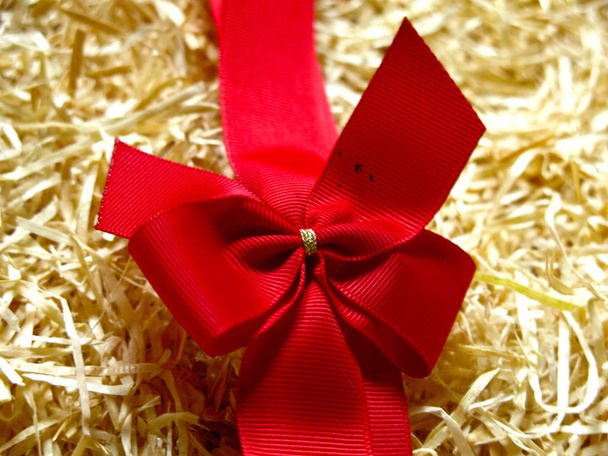czerwony Boże Narodzenie prezent łuk na tle trocin - Zdjęcie, obraz