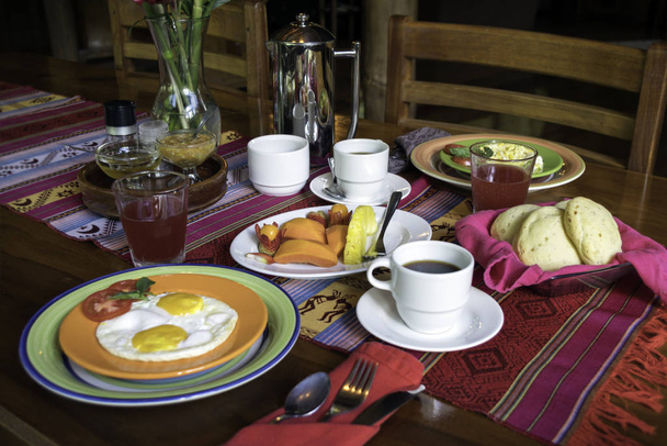 Вкусный южноамериканский завтрак с кофе, хлебом, яйцами, соком и свежими фруктами
 - Фото, изображение