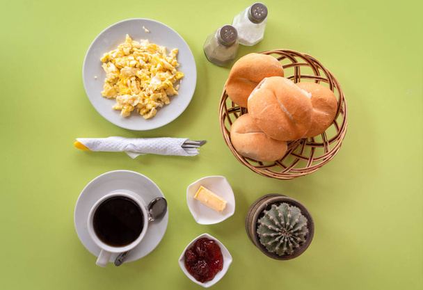 Colazione a base di caffè, uova strapazzate, pane, burro, caramelle e posate
 - Foto, immagini