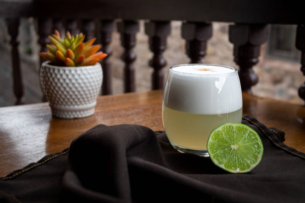 Classic Peruvian Pisco Sour served on a table with a lime - Foto, Bild