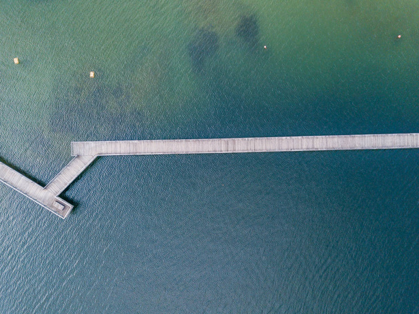 Vista aérea del puente peatonal sobre el lago. Puente de madera estrecho
 - Foto, imagen