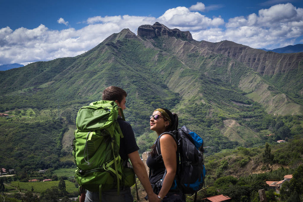 Batohem pár drží ruce obklopené přírodní krajinou. Vilcabamba, Ekvádor - Fotografie, Obrázek