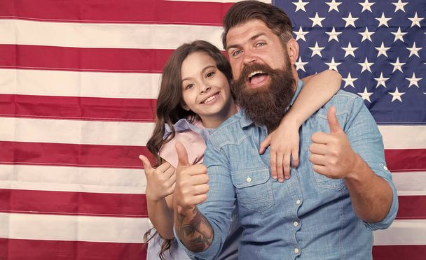 Thumbs ups for Independence. Father and little child gesturing on Independence day on american flag background. Happy family commemorating anniversary of nations independence. Happy Independence day - Foto, afbeelding