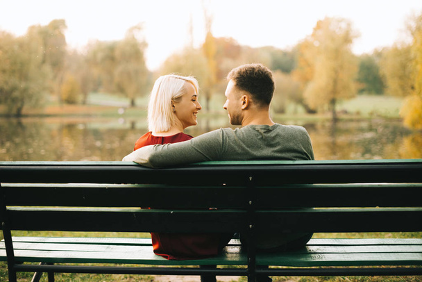 Photo of young couple sitting on bench - Photo, Image