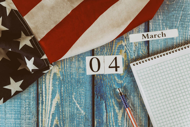 04 Március naptári nap Zászló az Amerikai Egyesült Államok szimbóluma a szabadság és a demokrácia üres jegyzettömbbel és tollal az irodai fa asztalon - Fotó, kép