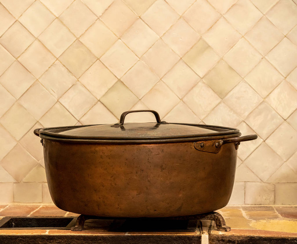 Antigua cacerola de cobre o olla en la encimera de la cocina
 - Foto, imagen