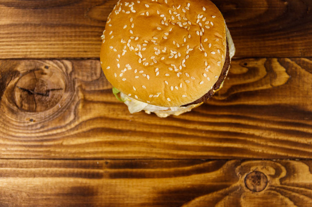 Heerlijke grote hamburger op houten tafel - Foto, afbeelding