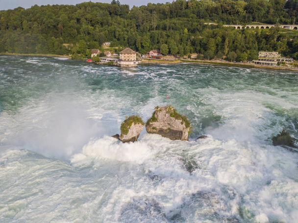 スイスのスイス国旗のあるシャフハウゼン付近では、ラインの落下水の中の岩石が空中から見ることができる。 - 写真・画像