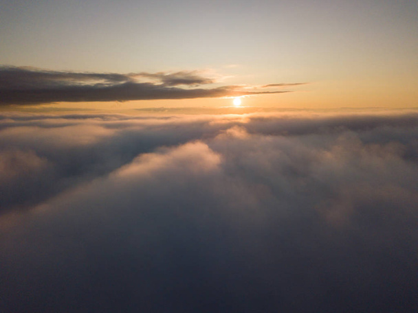 Vista por encima de las nubes durante el amanecer. Vista dramática del cielo
. - Foto, Imagen