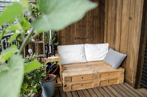 Cozy wooden pallet couch on balcony - Fotoğraf, Görsel