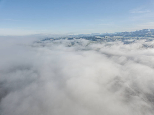 Aerial view of rural landscape in Switzerland covered with fog.  - Foto, Bild