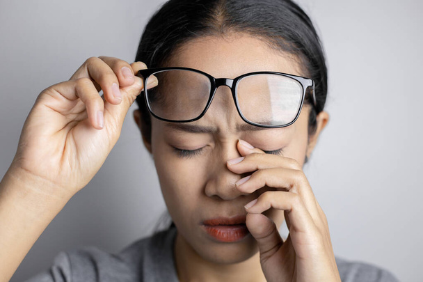 Οι γυναίκες κρατούν γυαλιά και υποφέρουν από πόνο στα μάτια. - Φωτογραφία, εικόνα