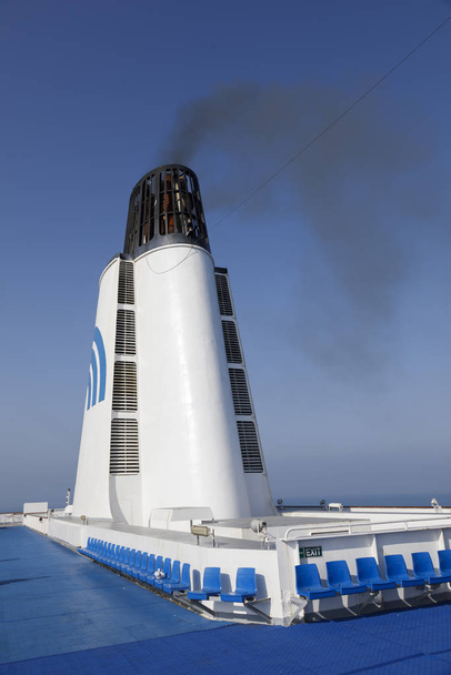 Durres, Albania, July 4 2019: Smoking chimney of a passenger ferry in the Mediterranean. Emission of soot particles and polluting exhaust gases - Photo, image