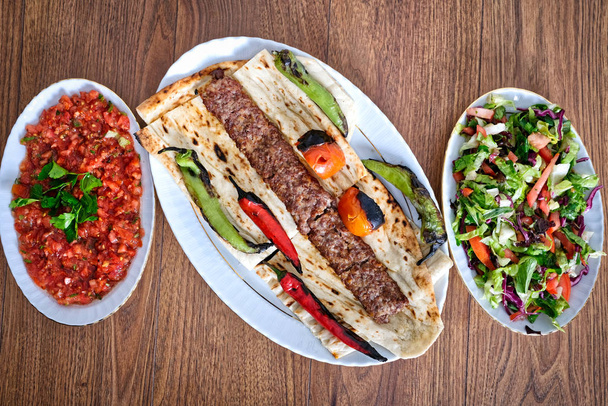 Турецкий стиль Adana Kebab. Традиционная турецкая еда Adana Кебаб на деревянном столе
. - Фото, изображение