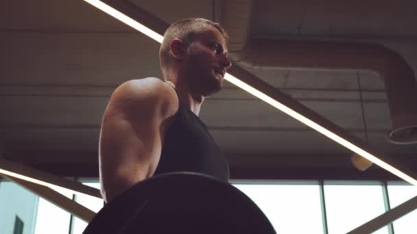 Athletic handsome male sportsman working in the gym using barbell. Strong and healthy bodybuilder abdominal training exercises. Sport, fitness, workout and lifestyle concept. - Footage, Video