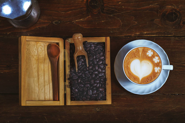 Kávové zrno ve dřevěné krabici s pozdní umělecké kávy na staré dřevo backgro - Fotografie, Obrázek