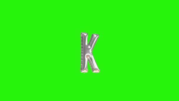 Stříbrné písmeno K. Stříbrná fólie helium balón abeceda plovoucí na zelené obrazovce - Záběry, video