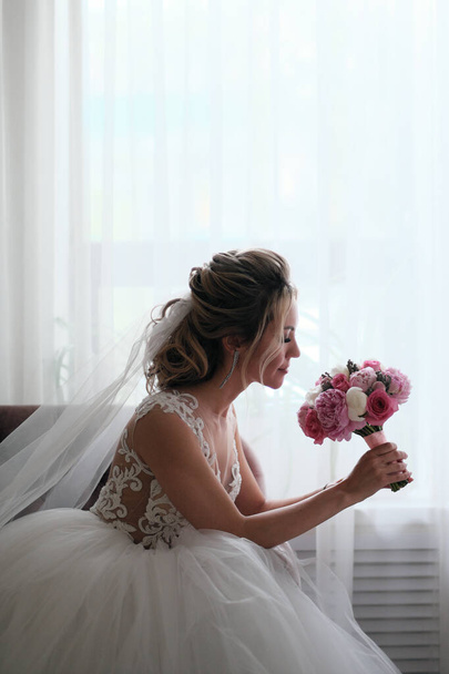 Blonde woman in wedding dress with bouquet - Fotografie, Obrázek