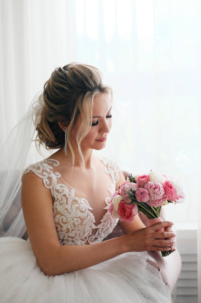 Blonde woman in wedding dress with bouquet - Foto, afbeelding